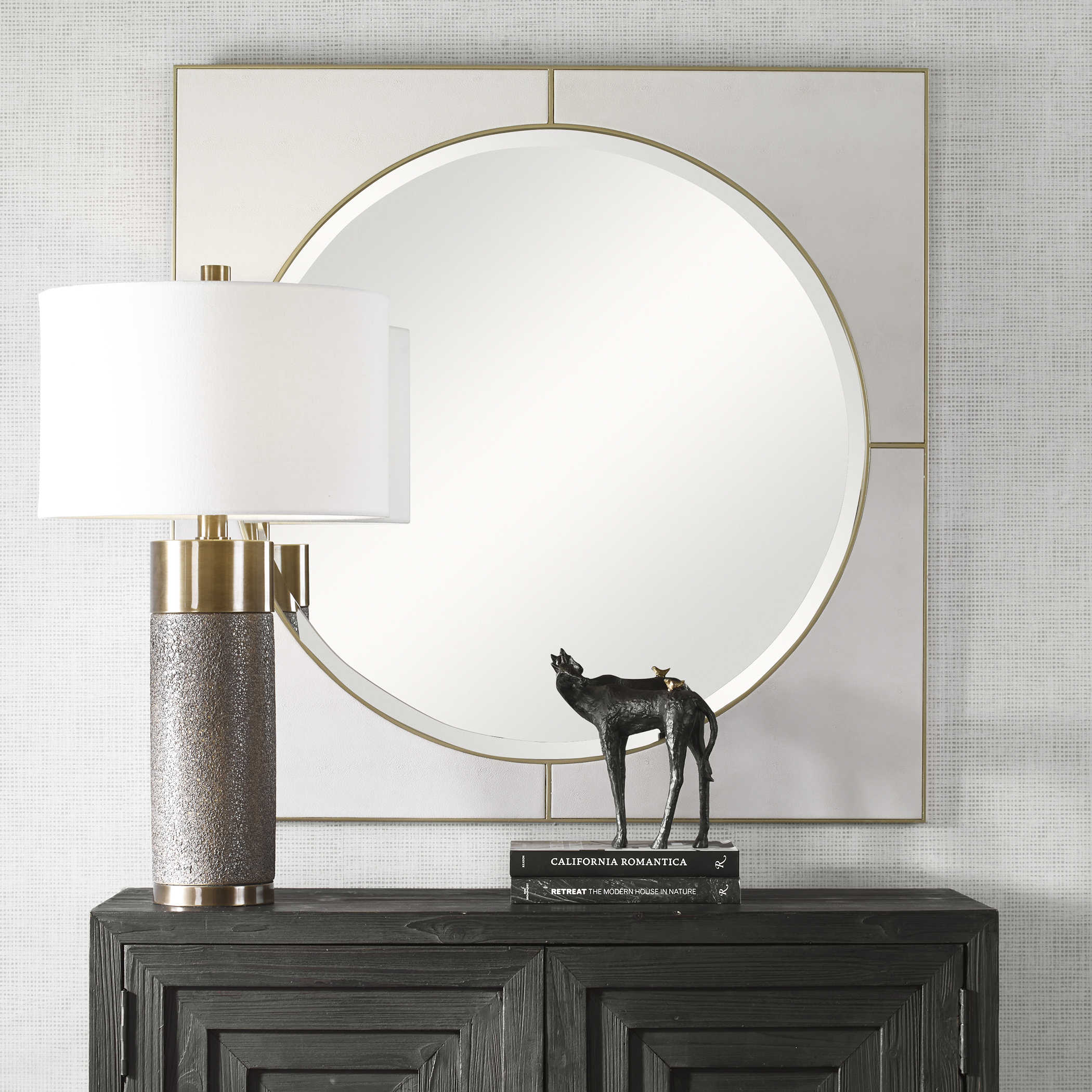Decorate with leather mirrors. Elevate your walls with a leather mirror. This photo shows a circular mirror surrounded by a square of faux leather encased in a gold frame