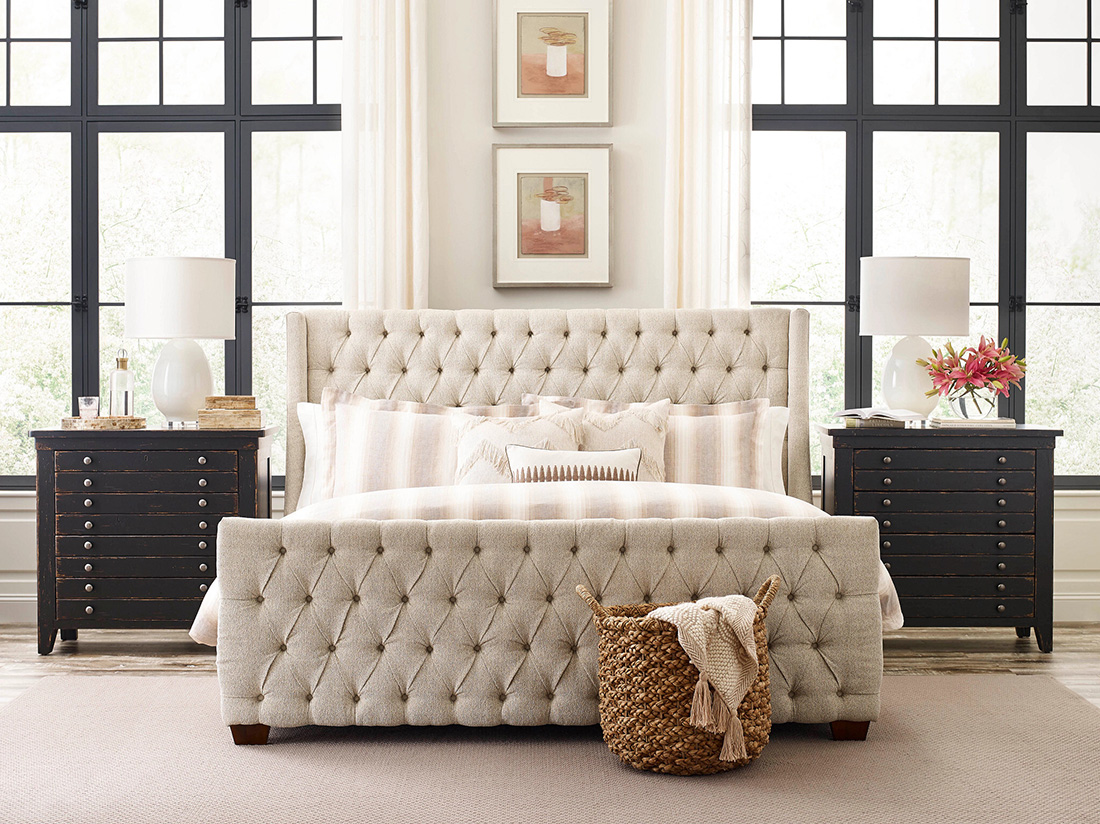 Elegant bedroom featuring mix and match bedroom furniture with a tufted upholstered bed, black vintage-style nightstands, and neutral-toned decor for a stylish look.