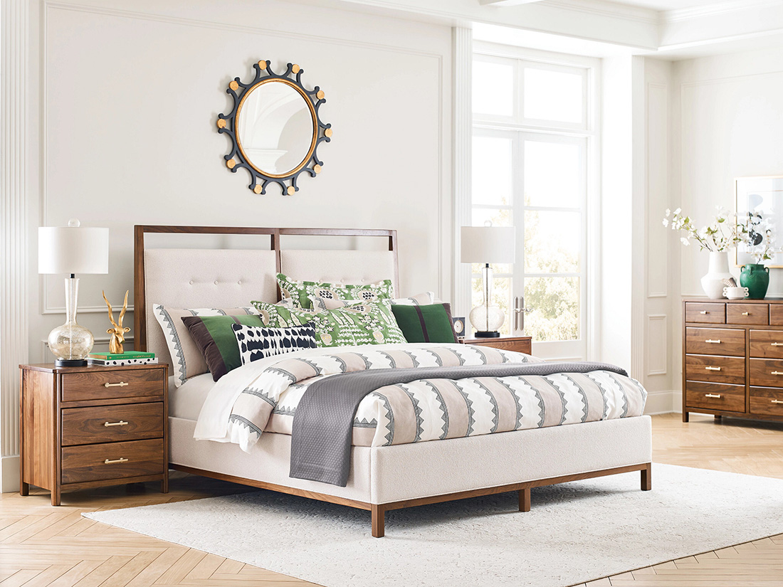 Bright and modern bedroom featuring mix and match bedroom furniture with an upholstered wood-trimmed bed, walnut nightstands, and stylish decor for a curated look.