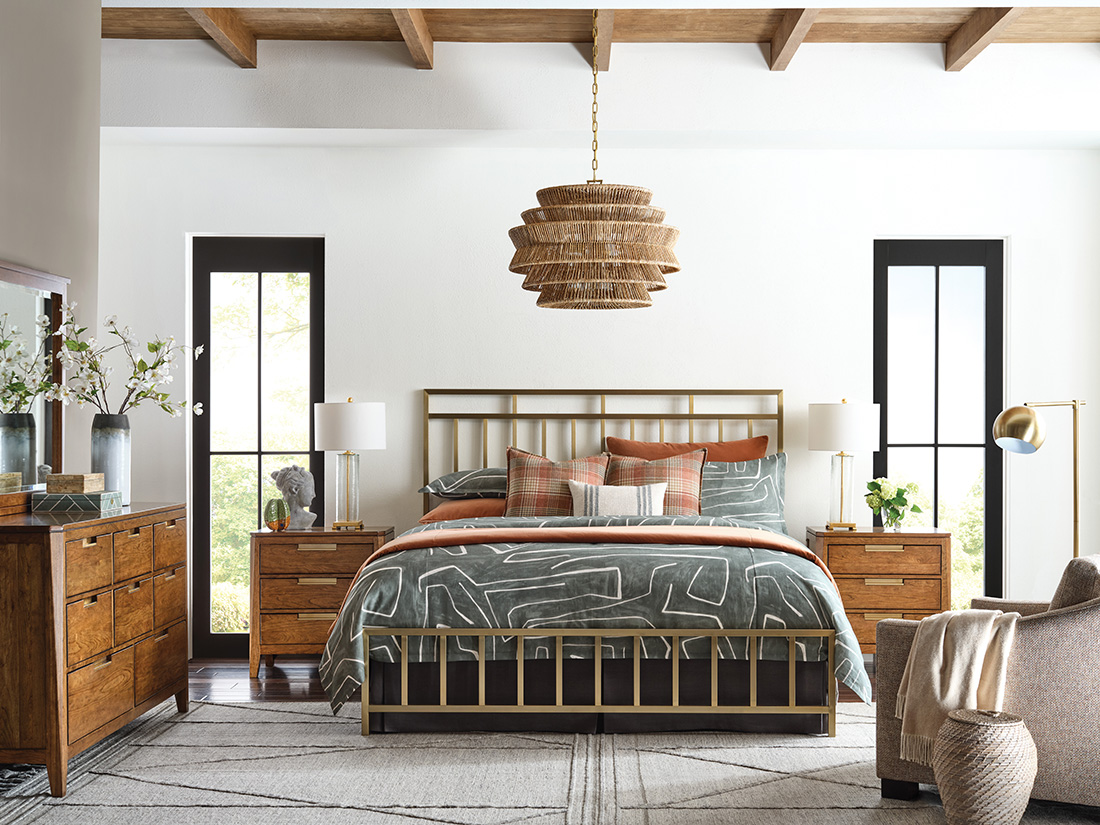 Stylish bedroom showcasing mix and match bedroom furniture with a brushed gold metal bed, solid wood nightstands, and warm-toned décor for a designer look.