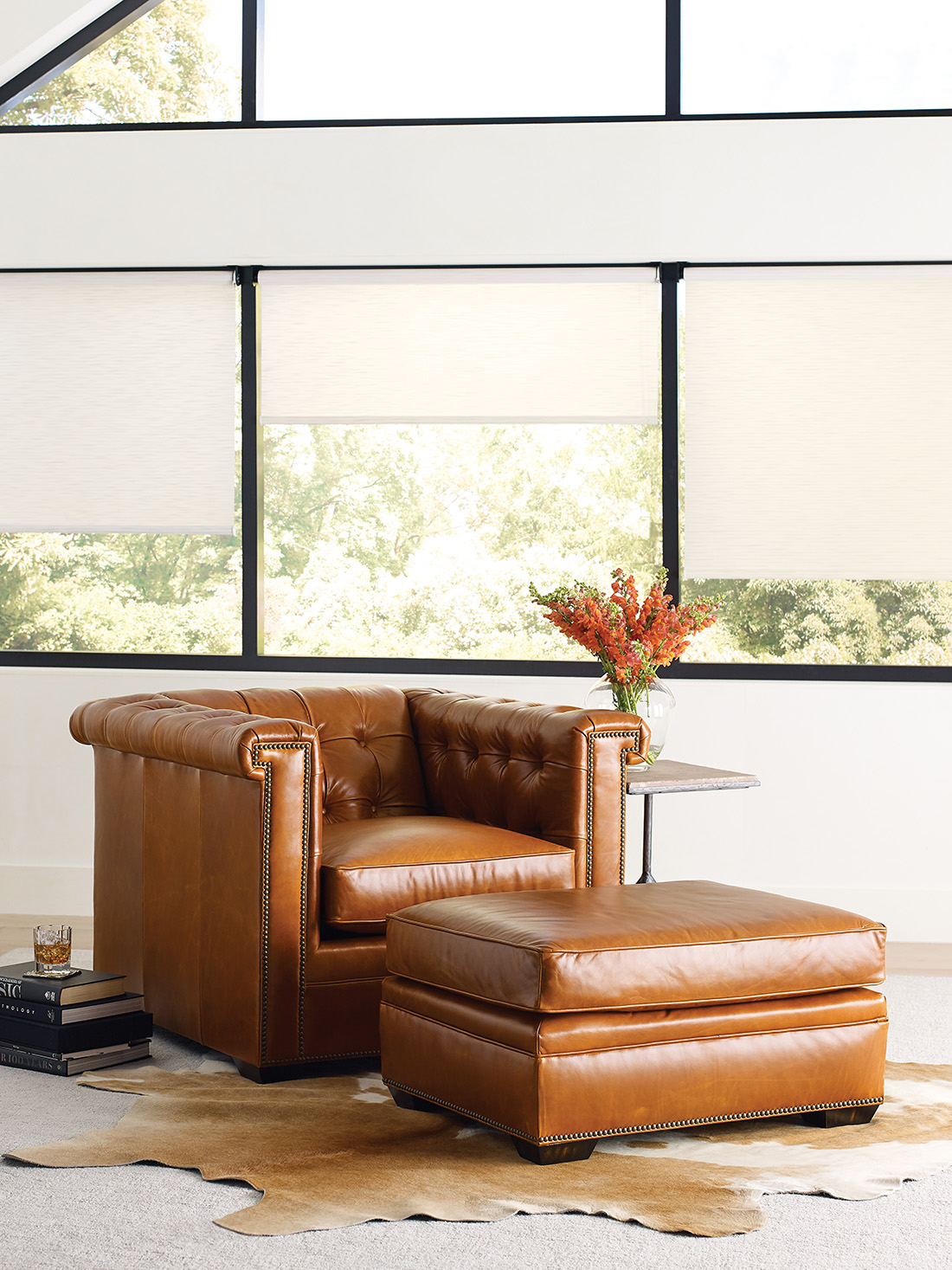 Timeless furniture featuring a tufted leather club chair with matching ottoman in a sunlit living space, styled with classic details and warm tones.