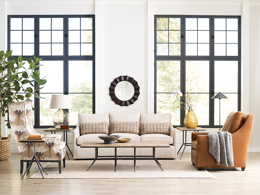 Bright, neutral-toned living room featuring a transitional design with modern accents and classic furniture pieces, including a linen sofa and wingback chairs.