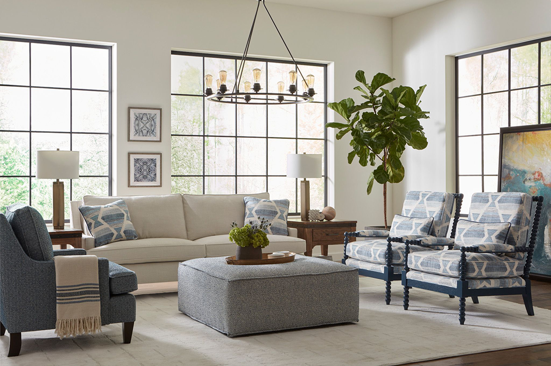 Bright living room featuring a neutral Kincaid sofa with blue accent chairs and oversized ottoman — a stylish and versatile setup to update your living room with ease.