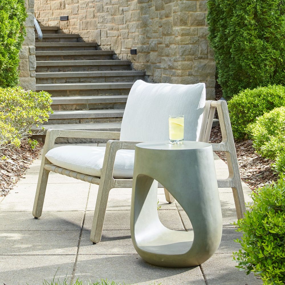 Stylish outdoor furniture from Uttermost featuring a cushioned lounge chair and modern accent table on a garden patio.