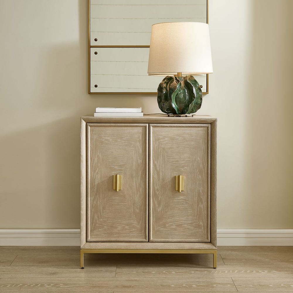 A small birch color accent chest with gold metal feet and handles
